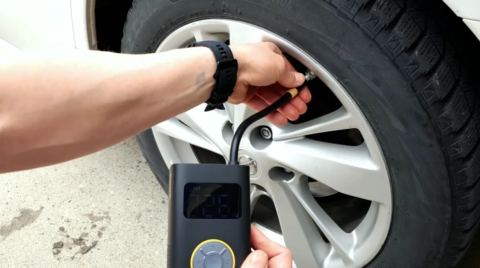 Fanttik X9 Pro inflating a car tire with its digital PSI display lit